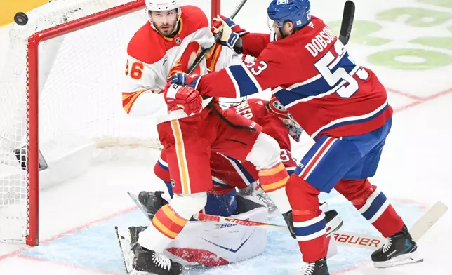 Montreal Canadiens' Noah Dobson (53) defends against Calgary Flames' Joel Farabee (86) as he moves in on Canadiens goaltender Jacob Fowler (32) during second period of an NHL hockey game in Montreal, Wednesday, Jan. 7, 2026. (Graham Hughes/The Canadian Press via AP)