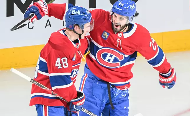 Montreal Canadiens' Lane Hutson (48) celebrates with teammate Phillip Danault (24) after scoring against the Calgary Flames during the second period of an NHL hockey game in Montreal, Wednesday, Jan. 7, 2026. (Graham Hughes/The Canadian Press via AP)