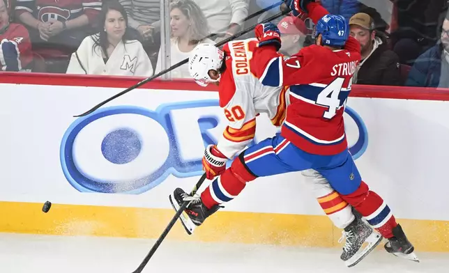 Montreal Canadiens' Jayden Struble (47) and Calgary Flames' Blake Coleman (20) battle along the boards during the first period of an NHL hockey game in Montreal, Wednesday, Jan. 7, 2026. (Graham Hughes/The Canadian Press via AP)