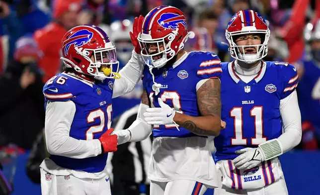 Buffalo Bills running back Ty Johnson (26) celebrates after scoring a touchdown on a pass from quarterback Mitchell Trubisky (11) in the second half of an NFL football game against the New York Jets Sunday, Jan. 4, 2026, in Orchard Park, N.Y. (AP Photo/Adrian Kraus)