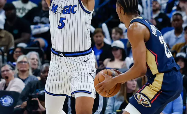 New Orleans Pelicans forward Trey Murphy III, right, is defended by Orlando Magic forward Paolo Banchero (5) during the second half of an NBA basketball game Sunday, Jan. 11, 2026, in Orlando, Fla. (AP Photo/Kevin Kolczynski)