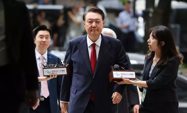 FILE - Former South Korean President Yoon Suk Yeol, center, arrives at a court to attend a hearing to review his arrest warrant requested by special prosecutors in Seoul, South Korea, July 9, 2025. (Kim Hong-Ji/Pool Photo via AP, File)