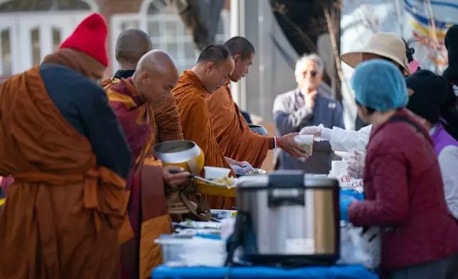 Buddhist monks who are participating in the, "Walk For Peace," get lunch Thursday, Jan. 8, 2026, in Saluda, S.C. (AP Photo/Allison Joyce)