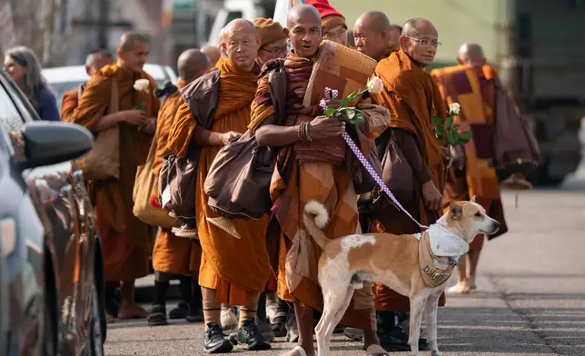 Buddhist monks who are participating in the, "Walk For Peace," are seen with their dog, Aloka, Thursday, Jan. 8, 2026, in Saluda, S.C. (AP Photo/Allison Joyce)