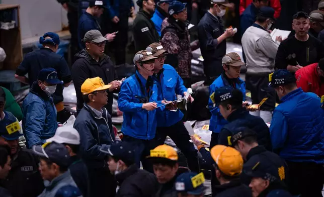 Wholesalers and buyers take part in the New Year's tuna auction at Toyosu fish market in Tokyo, Monday, Jan. 5, 2026. (AP Photo/Louise Delmotte)