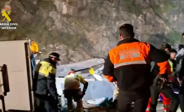 In this grab taken from video provided by Guardia Civil, rescue workers at the scene after a high speed train collision, in Adamuz, Spain, Monday, Jan. 19, 2026. (Guardia Civil via AP)