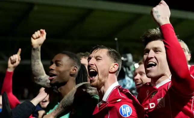 Wrexham's goalkeeper Arthur Okonkwo, left, celebrates with teammates after a penalty shootout at the end of the English FA Cup third round soccer match between Wrexham and Nottingham Forest in Wrexham, Wales, Friday, Jan. 9, 2026. (AP Photo/Jon Super)