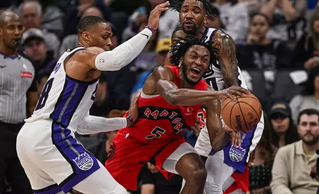 Toronto Raptors guard Immanuel Quickley (5) is fouled by Sacramento Kings guard Malik Monk (0) during the first half of an NBA basketball game, Wednesday, Jan. 21, 2026, in Sacramento, Calif. (AP Photo/Justine Willard)