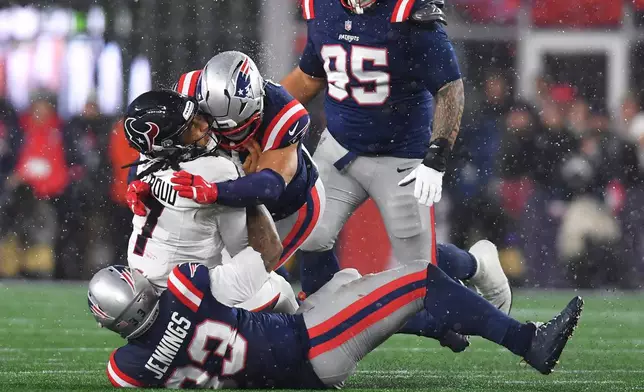 Houston Texans quarterback C.J. Stroud (7) is tackled by New England Patriots linebacker Anfernee Jennings, bottom, and linebacker Christian Elliss during the second half of an NFL divisional playoff football game, Sunday, Jan. 18, 2026, in Foxborough, Mass. (AP Photo/Steven Senne)