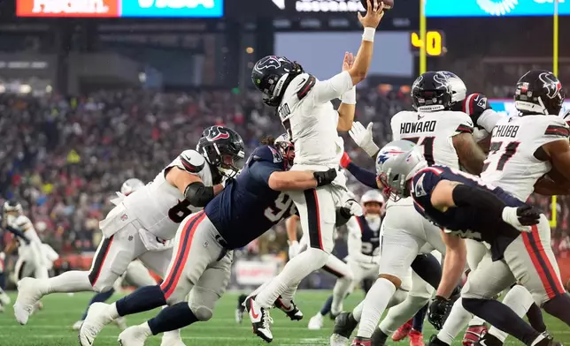 Houston Texans quarterback C.J. Stroud, middle, is hit by New England Patriots defensive tackle Khyiris Tonga while throwing an incomplete pass during the first half of an NFL divisional playoff football game, Sunday, Jan. 18, 2026, in Foxborough, Mass. (AP Photo/Robert F. Bukaty)