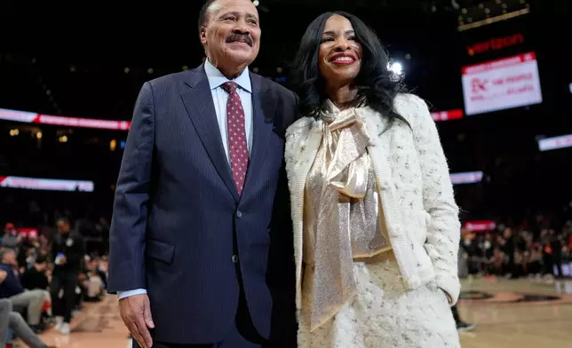 Martin Luther King III, and his wife Arndrea Waters King smile during the second half of an NBA basketball game between the Atlanta Hawks and the Milwaukee Bucks, Monday, Jan. 19, 2026, in Atlanta. (AP Photo/Mike Stewart)