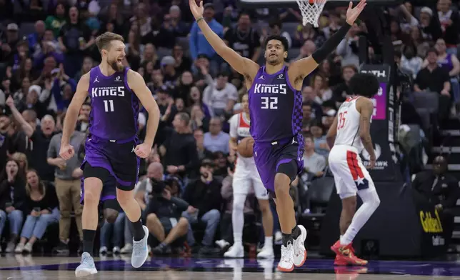 Sacramento Kings center Dylan Cardwell (32) reacts after dunking the ball during the first half of an NBA basketball game against the Washington Wizards, Friday, Jan. 16, 2026, in Sacramento, Calif. (AP Photo/Scott Marshall)