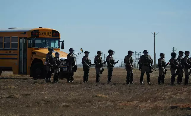 Texas state troopers wearing riot gear arrive to help disperse protesters gathered outside the South Texas Family Residential Center detention facility where Liam Ramos and his father are being detained in Dilley, Texas, Wednesday, Jan. 28, 2026. (AP Photo/Eric Gay)