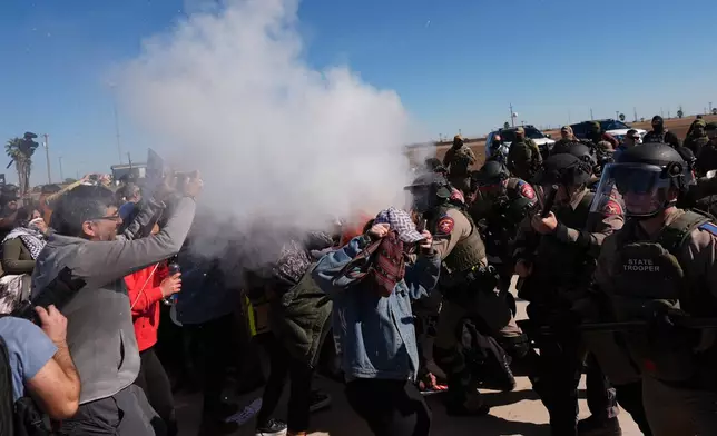 Pepper spray is dispersed towards protesters outside the South Texas Family Residential Center detention facility where Liam Ramos and his father are being detained in Dilley, Texas, Wednesday, Jan. 28, 2026. (AP Photo/Eric Gay)