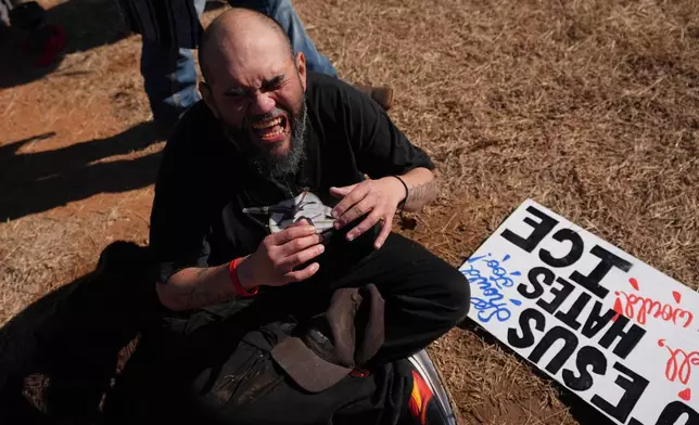 A protester reacts to the effects of pepper spray launched by Texas troopers to disperse protesters outside the South Texas Family Residential Center detention facility where Liam Ramos and his father are being detained in Dilley, Texas, Wednesday, Jan. 28, 2026. (AP Photo/Eric Gay)