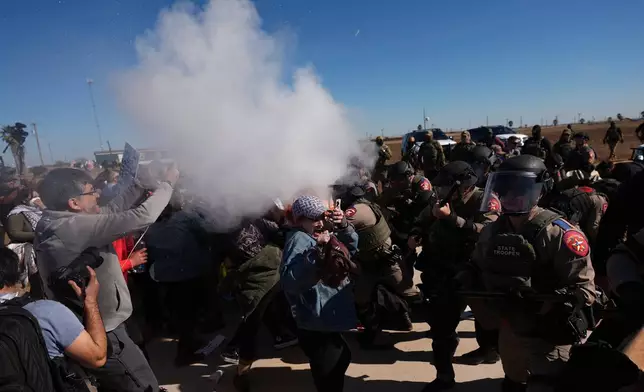 Pepper spray is dispersed towards protesters outside the South Texas Family Residential Center detention facility where Liam Ramos and his father are being detained in Dilley, Texas, Wednesday, Jan. 28, 2026. (AP Photo/Eric Gay)