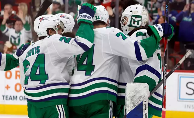 Carolina Hurricanes goaltender Brandon Bussi, right, is congratulated after his win over the Utah Mammoth in an NHL hockey game in Raleigh, N.C., Thursday, Jan. 29, 2026. (AP Photo/Karl DeBlaker)