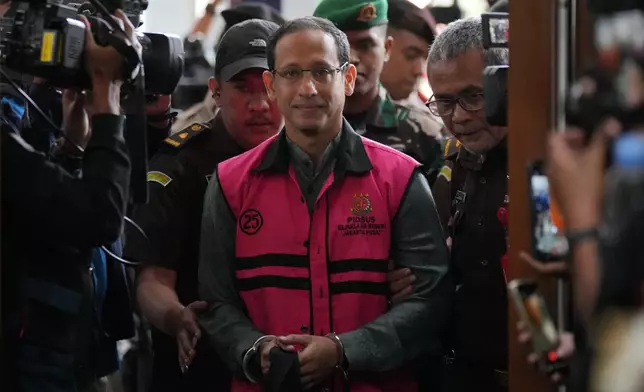 Nadiem Anwar Makarim, center, the co-founder of Indonesia's payments platform and ride hailing company Gojek and former education minister, enters the courtroom for his first trial hearing at the Corruption Court in Jakarta, Indonesia, Monday, Jan. 5, 2026. (AP Photo/Tatan Syuflana)