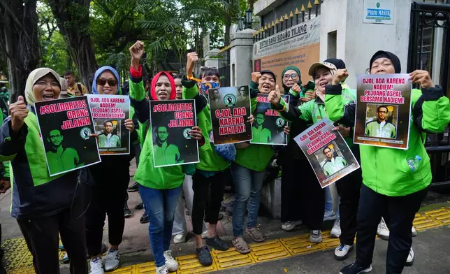 Ride hailing drivers hold posters supporting Nadiem Anwar Makarim, the co-founder of Indonesia's payments platform and ride hailing company Gojek and former education minister, as they shout slogans outside the Corruption Court where Makarim's trial hearing is held in Jakarta, Indonesia, Monday, Jan. 5, 2026. (AP Photo/Tatan Syuflana)