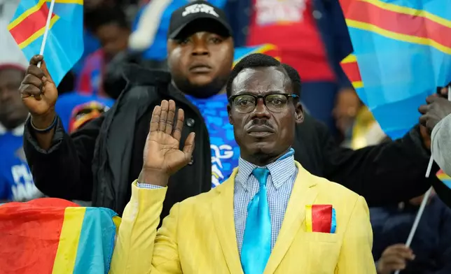 Michel Nkuka Mboladinga, a DR Congo fan impersonating late Congolese leader Patrice Lumumba, strikes a pose during the Africa Cup of Nations group D soccer match between Botswana and DR Congo in Rabat, Morocco, Tuesday, Dec. 30, 2025. (AP Photo/Mosa'ab Elshamy)