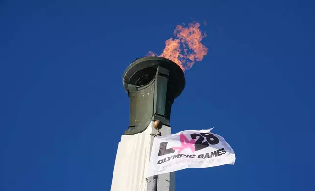 The Olympic cauldron is lit at the Los Angeles Memorial Coliseum ahead of the launch for ticket registration to the 2028 Summer Olympic Games Tuesday, Jan. 13, 2026, in Los Angeles. (AP Photo/Damian Dovarganes)