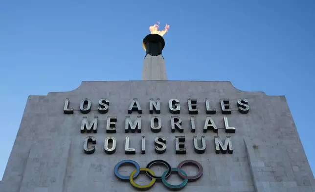 The Olympic cauldron is lit at the Los Angeles Memorial Coliseum ahead of the launch for ticket registration to the 2028 Summer Olympic Games Tuesday, Jan. 13, 2026, in Los Angeles. (AP Photo/Damian Dovarganes)
