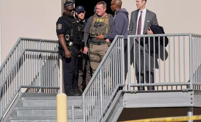 FBI officers are seen at the Fulton County Election Hub and Operation Center, Wednesday, Jan. 28, 2026, in Union City, Ga, near Atlanta. (AP Photo/Mike Stewart)