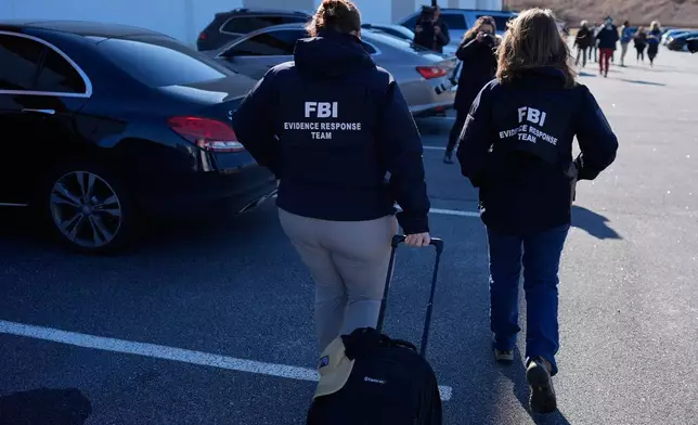 FBI officers are seen at the Fulton County Election Hub and Operation Center, Wednesday, Jan. 28, 2026, in Union City, Ga, near Atlanta. (AP Photo/Mike Stewart)