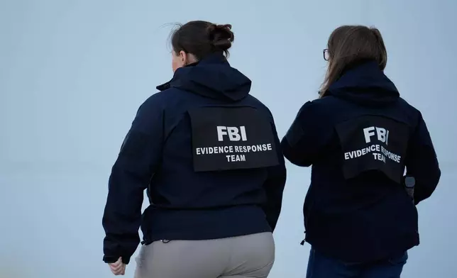 FBI officers are seen at the Fulton County Election Hub and Operation Center, Wednesday, Jan. 28, 2026, in Union City, Ga, near Atlanta. (AP Photo/Mike Stewart)