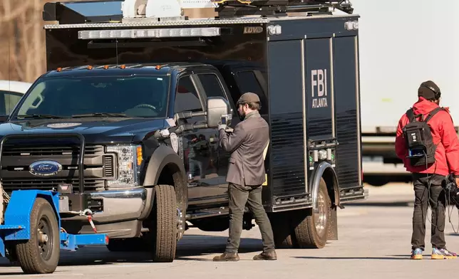 FBI officers are seen at the Fulton County Election Hub and Operation Center, Wednesday, Jan. 28, 2026, in Union City, Ga, near Atlanta. (AP Photo/Mike Stewart)