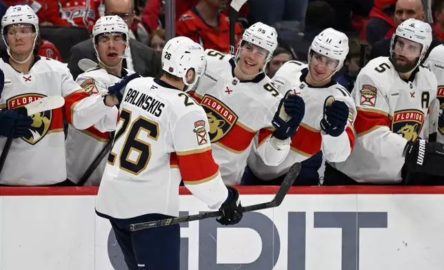 Florida Panthers defenseman Uvis Balinskis (26) is congratulated by teammates after scoring a goal during the second period of an NHL hockey game against the Washington Capitals, Saturday, Jan. 17, 2026, in Washington. (AP Photo/John McDonnell)
