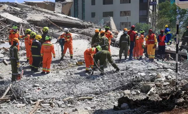 A rescue team searches for bodies following the collapse of a building in Nairobi, Kenya, Friday, Jan. 2, 2026. (AP Photo/Andrew Kasuku)