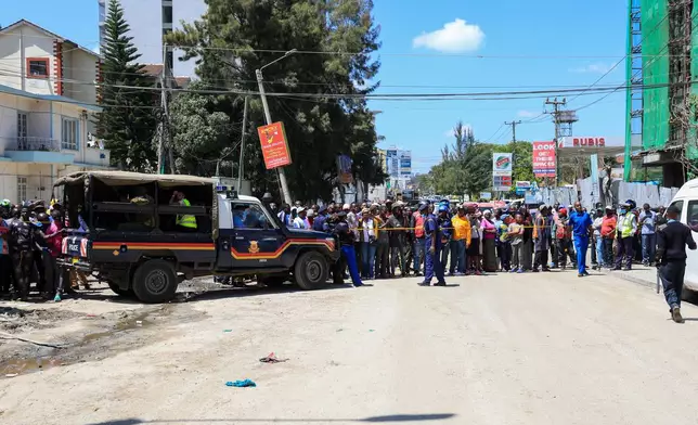 People gather near the scene of the collapsed building in Nairobi, Kenya, Friday, Jan. 2, 2026. (AP Photo/Andrew Kasuku)