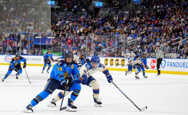 Fans look on as Toronto Sceptres defenseman Renata Fast (14) and Vancouver Goldeneyes defenseman Sophie Jaques (16) vie for control of the puck during second-period PWHL hockey game action in Toronto, Saturday, Jan. 17, 2026. (Frank Gunn/The Canadian Press via AP)