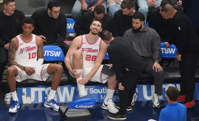 Houston Rockets center Alperen Sengun (28) reacts on the bench after taking a fall on a rebound attempt against the Dallas Mavericks during the first half of an NBA basketball game Saturday, Jan. 3, 2026, in Dallas. (AP Photo/Julio Cortez)