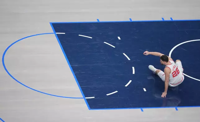 Houston Rockets center Alperen Sengun is slow to get up after falling on a play against the Dallas Mavericks during the first half of an NBA basketball game Saturday, Jan. 3, 2026, in Dallas. (AP Photo/Julio Cortez)