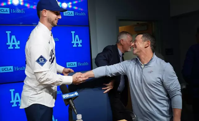 Outfielder Kyle Tucker, left, shakes hands with Andrew Friedman, Los Angeles Dodgers president of baseball operations during a news conference after joining the Los Angeles Dodgers baseball team, Wednesday, Jan. 21, 2026, in Los Angeles. (AP Photo/Damian Dovarganes)