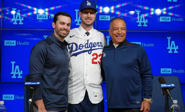 Outfielder Kyle Tucker, center, poses with Los Angeles Dodgers general manager Brandon Gomes, left, and manager Dave Roberts during a news conference after joining the Los Angeles Dodgers baseball team, Wednesday, Jan. 21, 2026, in Los Angeles. (AP Photo/Damian Dovarganes)