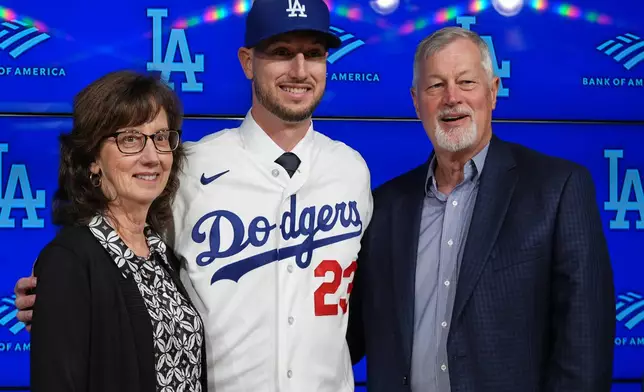 Outfielder Kyle Tucker, center, poses for pictures with his parents, Mike Tucker, right, and Lisa Fernandez during a news conference after joining the Los Angeles Dodgers baseball team, Wednesday, Jan. 21, 2026, in Los Angeles. (AP Photo/Damian Dovarganes)