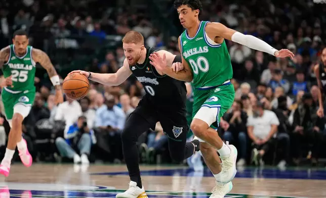 Minnesota Timberwolves guard Donte DiVincenzo (0) drives to the basket as Dallas Mavericks' Max Christie (00) defends in the first half of an NBA basketball game Wednesday, Jan. 28, 2026, in Dallas. (AP Photo/Tony Gutierrez)