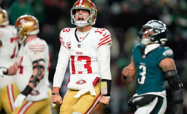 San Francisco 49ers quarterback Brock Purdy (13) reacts to a touchdown pass to 49ers running back Christian McCaffrey during the second half of an NFL wild-card playoff football game against the Philadelphia Eagles on Sunday, Jan. 11, 2026, in Philadelphia. (AP Photo/Chris Szagola)