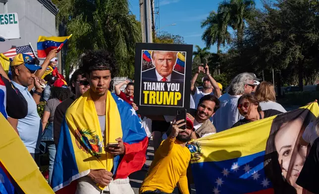 People celebrate after President Donald Trump announced Venezuelan President Nicolás Maduro had been captured and flown out of the country, in Doral, Fla., Saturday, Jan. 3, 2026. (AP Photo/Jen Golbeck)