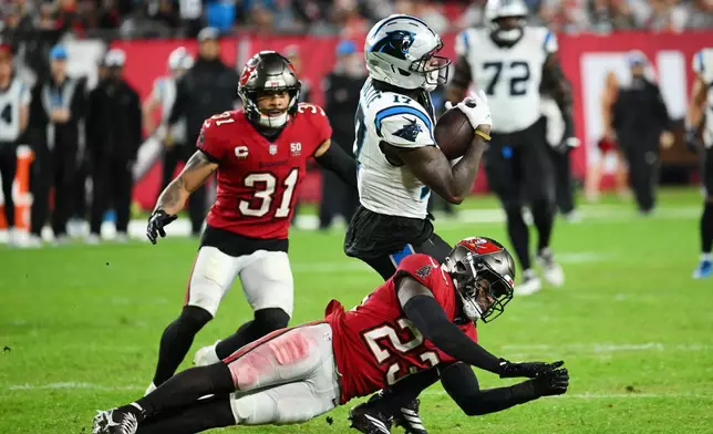 Carolina Panthers wide receiver Xavier Legette (17) makes a catch over Tampa Bay Buccaneers safety Tykee Smith (23) during the second half of an NFL football game Saturday, Jan. 3, 2026, in Tampa, Fla. (AP Photo/Jason Behnken)