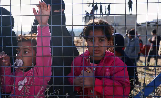 People stand inside the al-Hol camp in northeastern Syria's Hasakeh province, Syria, Wednesday, Jan. 21, 2026, after the withdrawal of the Syrian Democratic Forces (SDF). (AP Photo/Ghaith Alsayed)