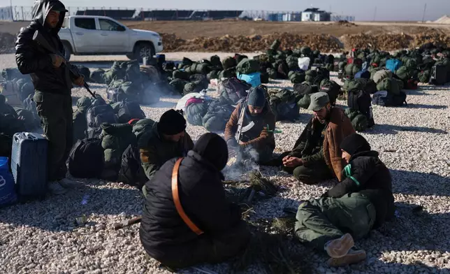 Syrian government forces with their luggage wait to enter the al-Hol camp in northeastern Syria's Hasakeh province, Syria, Wednesday, Jan. 21, 2026, after the withdrawal of the Syrian Democratic Forces (SDF). (AP Photo/Ghaith Alsayed)