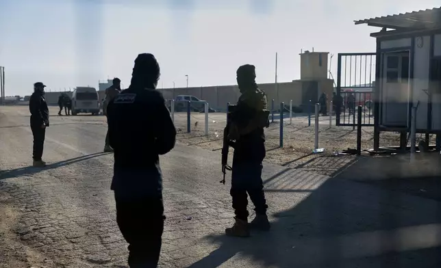 Syrian government troops stand guard at the entrance to the al-Hol camp in northeastern Syria's Hasakeh province, Syria, Wednesday, Jan. 21, 2026, after the withdrawal of the Syrian Democratic Forces (SDF). (AP Photo/Ghaith Alsayed)