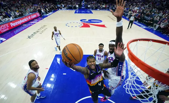 Phoenix Suns' Jalen Green, left, goes up for a shot against Philadelphia 76ers' Adem Bona during the second half of an NBA basketball game Tuesday, Jan. 20, 2026, in Philadelphia. (AP Photo/Matt Slocum)
