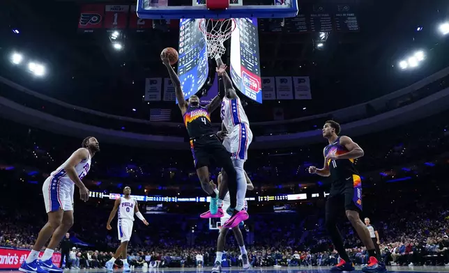 Phoenix Suns' Jalen Green, left, goes up for a shot against Philadelphia 76ers' Adem Bona during the second half of an NBA basketball game Tuesday, Jan. 20, 2026, in Philadelphia. (AP Photo/Matt Slocum)