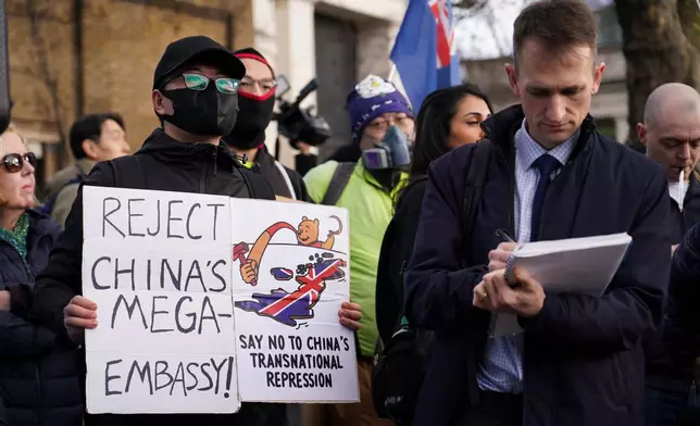 Demonstrators hold placards and flags as they attend a protest against the opening of the new Chinese embassy, in London, Saturday, Jan. 17, 2026. (AP Photo/Alberto Pezzali)