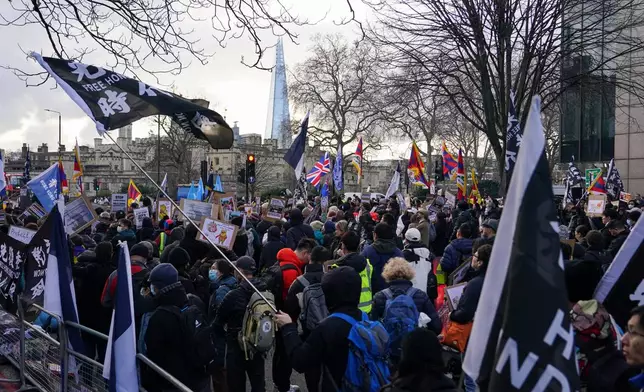 Demonstrators hold placards and flags as they attend a protest against the opening of the new Chinese embassy, in London, Saturday, Jan. 17, 2026. (AP Photo/Alberto Pezzali)